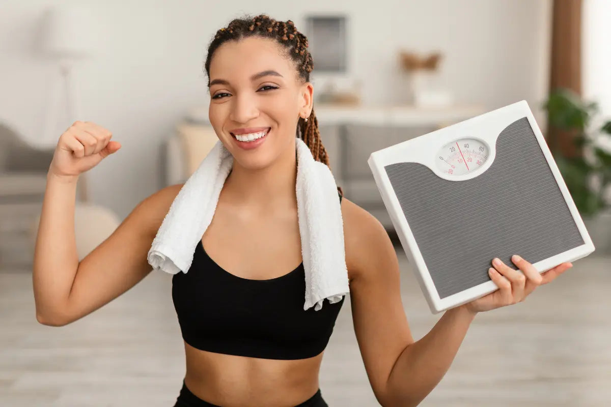femme qui montre ses biceps avec une balance de sport