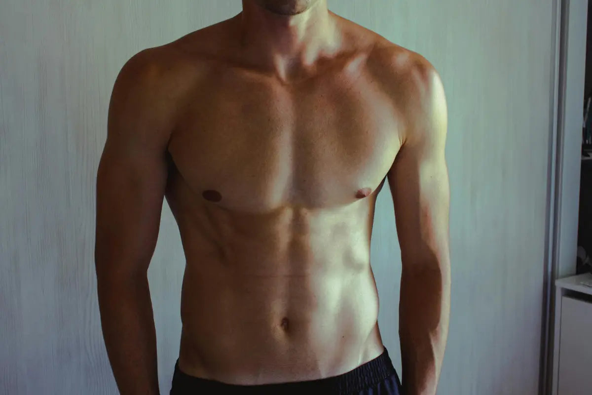 homme qui montre ses pectoraux musclés grâce aux exercices à la maison 