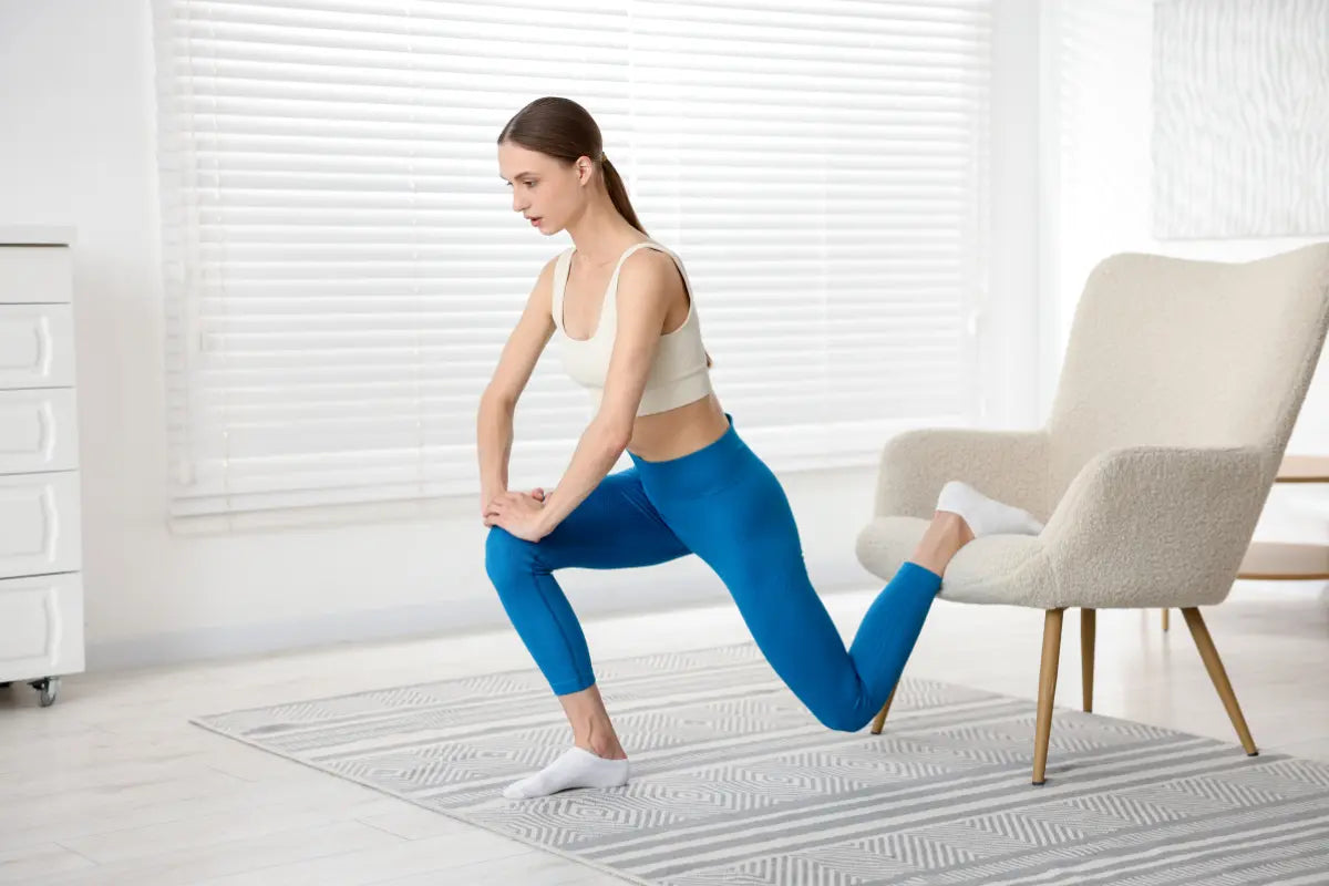 femme qui fait des fentes pour muscler ses jambes à la maison avec une chaise