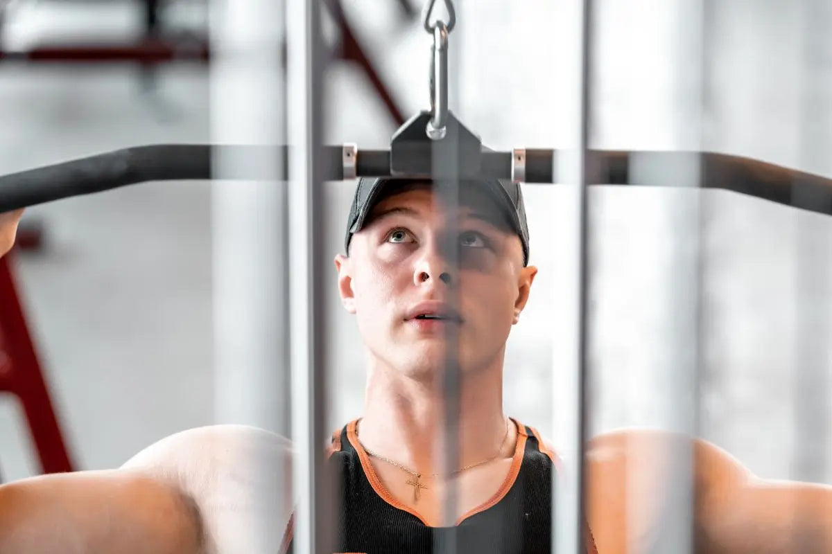 homme qui se muscle le dos en faisant du tirage vertical à la poulie